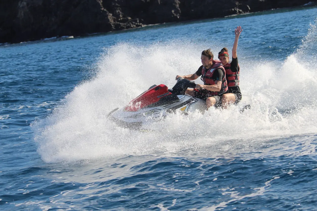 Riders and spray off the volcanic coast