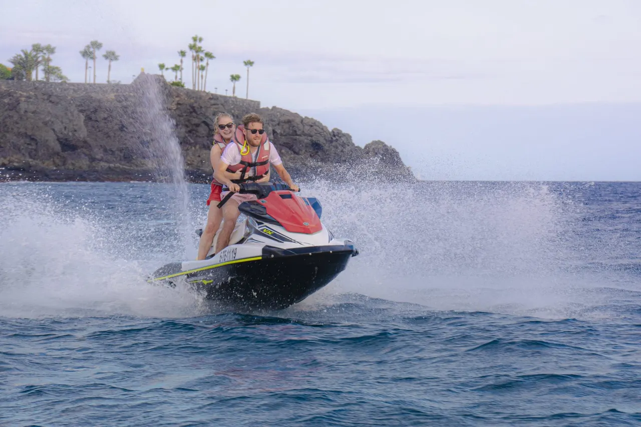 Two riders and spray along the shore